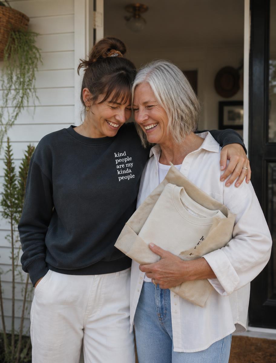 Two people on a doorstep, one holding a folded sweatshirt wrapped in tissue paper